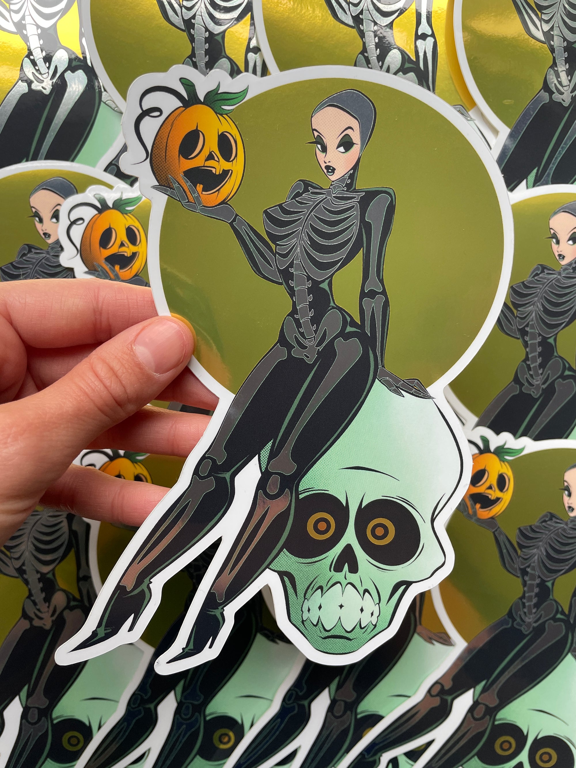 female skeleton holding pumpkin and sitting on skull jumbo mirror sticker by bloodknotcollective